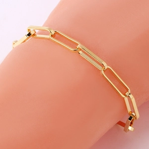 Close-up of golden paperclip link bracelet with polished metallic finish for women
