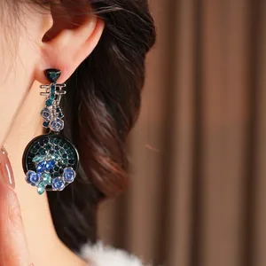 Vintage floral drop earrings with blue rose and crystals on elegant model