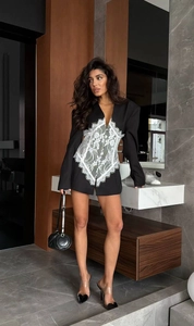 Detailed view of black blazer dress with white lace corset inlay and cinched waist