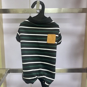 Striped pet jumpsuit with brown leather tag hanging on a black plastic paw-shaped hanger