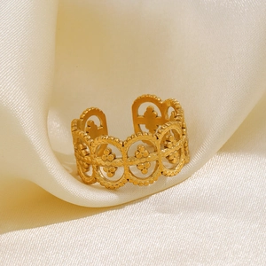 Adjustable golden bohemian hollow ring with geometric floral pattern on satin