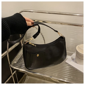 Detail of black vintage square shoulder bag with gold hardware and front snap pocket
