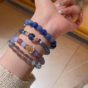 Stackable beaded bracelets set with blue zircon crystals and silver metal charms