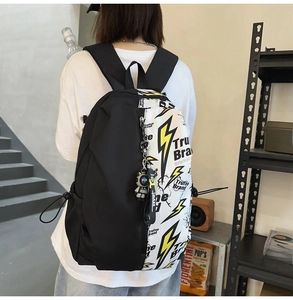 Detail of minimalist black and white backpack with lightning print and side buckle strap