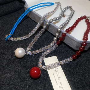 Detailed macro of zircon pearl and colorful crystal beaded necklaces on stone tray