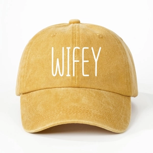 Close-up of mustard yellow washed canvas baseball cap with white WIFEY embroidery