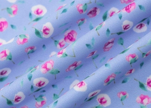 Vue macro de la texture du tissu floral violet avec fleurs roses et motif sergé