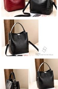 Detail view of crocodile pattern embossing and metal hardware on bucket bags