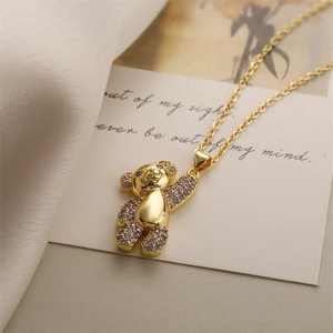 Dettaglio di una collana con ciondolo a orsetto d'oro con zirconi viola scintillanti