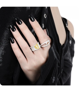 Close-up of stacked S925 silver rings with rock texture and amber stone on a model hand