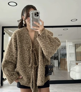 Detail of soft brown faux fur knit cardigan with tie-front closure and plush texture