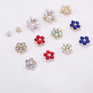 Detailed macro view of colorful 3D flower nail charms with rhinestones and pearls