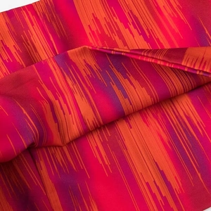 Detaillierte Makroansicht des orange-violett gestreiften Bohème-Stoffs mit Seidentextur