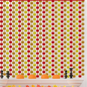 Detailed view of autumn maple leaf tinsel curtains in red, orange, and gold colors