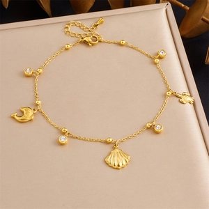 Gold plated stainless steel anklet featuring sea turtle, dolphin, and shell charms with zircons