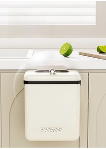 Detail of wall-mounted kitchen trash can with lid hanging on cabinet door