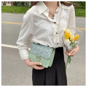 Detail of green sequin crossbody bag with gold chain strap and ring buckle closure