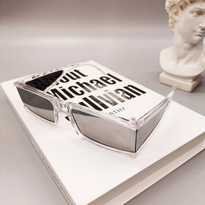 Artistic display of square sunglasses with transparent frames on a vintage book background