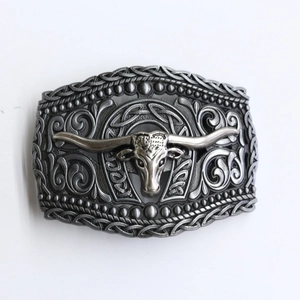 Detailed close-up of a retro zinc alloy belt buckle with bull skull and scrollwork design