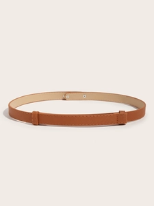 Detailed view of brown slim waist belt with metal buckle and fine textured synthetic leather