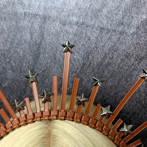 Detail of starry halo crown headband with silver stars and spikes on brown base