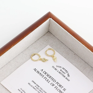 Close-up of golden S925 heart huggie earrings with Best Friends engraved detail
