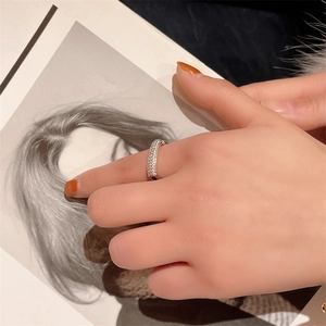 Close-up of a silver geometric open ring with micro-pave clear zircons on a finger