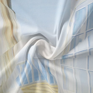 Close-up of bohemian silk scarf featuring light blue architectural patterns and sheer fabric