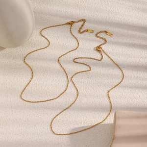 Minimalist 18K gold plated stainless steel O-chain necklace on a textured surface