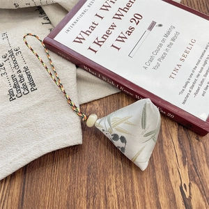 Detail of a handmade zongzi pendant with bamboo leaf pattern and colorful silk cord