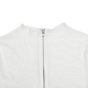 Détail de la fermeture éclair métallique au dos d'une robe blanche en maille filet