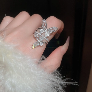 Detail of elegant silver butterfly ring with sparkling zircons on a person's hand