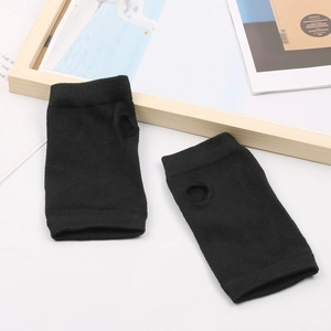 Détail de gants tricotés noirs sans doigts avec trou pour le pouce sur fond minimaliste