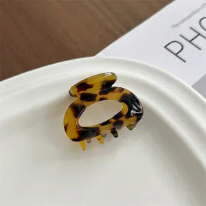 Detailed macro view of the leopard print acetate hair claw clip with a hollow oval design