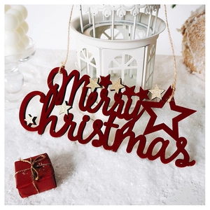 Close-up of red wooden Merry Christmas sign with gold glitter stars on a snowy setup