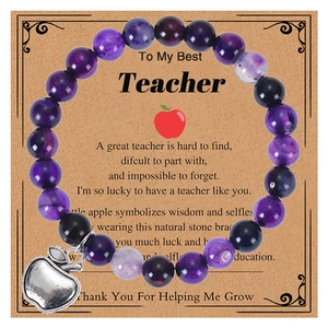 Detail of purple natural stone beaded bracelet with silver apple charm on a gift card