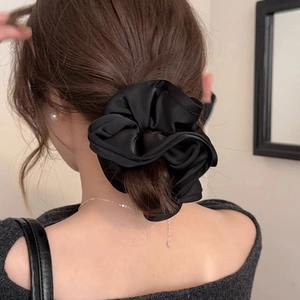 Large black satin scrunchie with French vintage ruffle design on a low ponytail hair