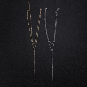 Detail of gold and silver double-layered Y-shaped necklaces with small bead accents