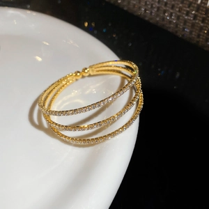 Détail d'un bracelet croisé doré multicouche avec micro-incrustations de zircons brillants