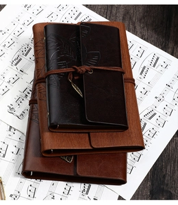 Detail of vintage leather notebooks in three sizes with leaf embossing and tie closure