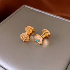 Gold plated sunburst earrings with zircon and turquoise on brushed grey display box