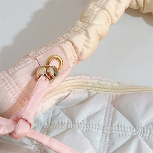Detailed close-up of quilted pink gradient bag showing metal ring and drawstring