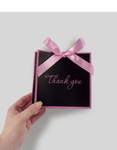 Detailed macro view of a black gift box with a pink ribbon and Thank You text