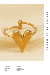 Macro detail of golden heart-shaped open ring with faceted band and polished finish