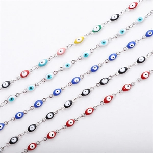 Detailed macro view of multicolor Evil Eye charms on stainless steel chain bracelets