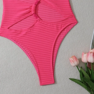 Gros plan du maillot de bain rose côtelé une pièce avec nœud tressé et découpes latérales
