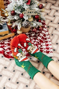 Close-up of fluffy Christmas socks with Santa embroidery and festive decorations