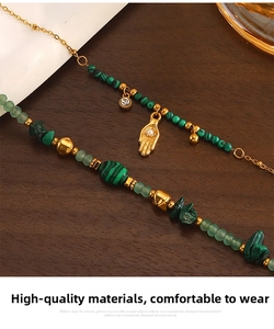 Détail du pendentif main de fatma bohème avec perles de malachite et finition dorée