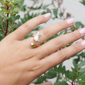 Detail shot of 3D bunny and floral adjustable ring on hand with green nature background