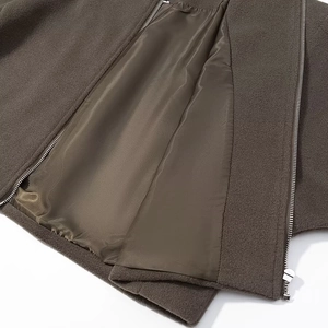 Detail view of dark brown wool coat featuring smooth satin lining and premium metal zipper